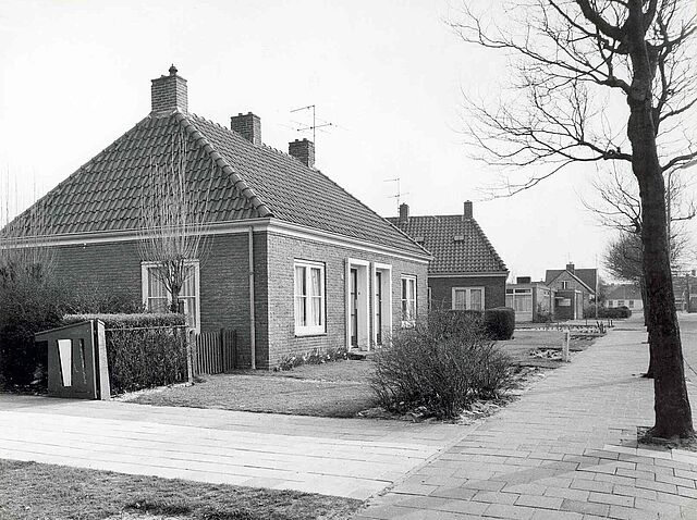 Gezicht op de bejaardenwoningen aan de Kerklaan richting centrum. Daarachter de dependance van het gemeentesecretarie. Situatie 1968.